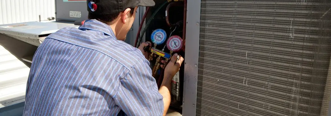 HVAC technician servicing a condenser unit in Lufkin