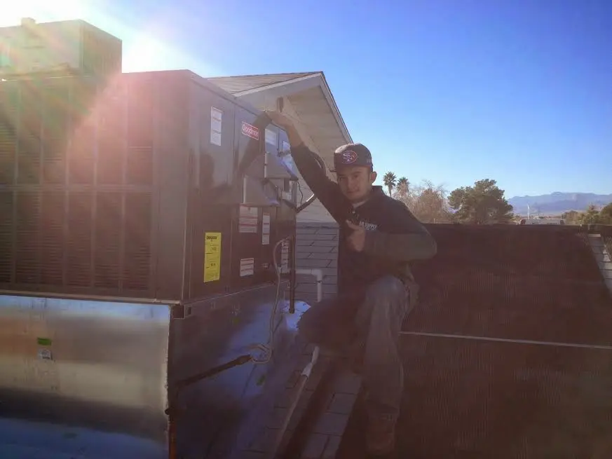 HVAC technician performing Air Duct Cleaning on a rooftop unit in Lufkin